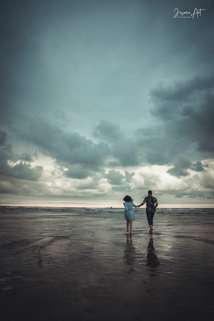 Pareja de novios corriendo por la playa